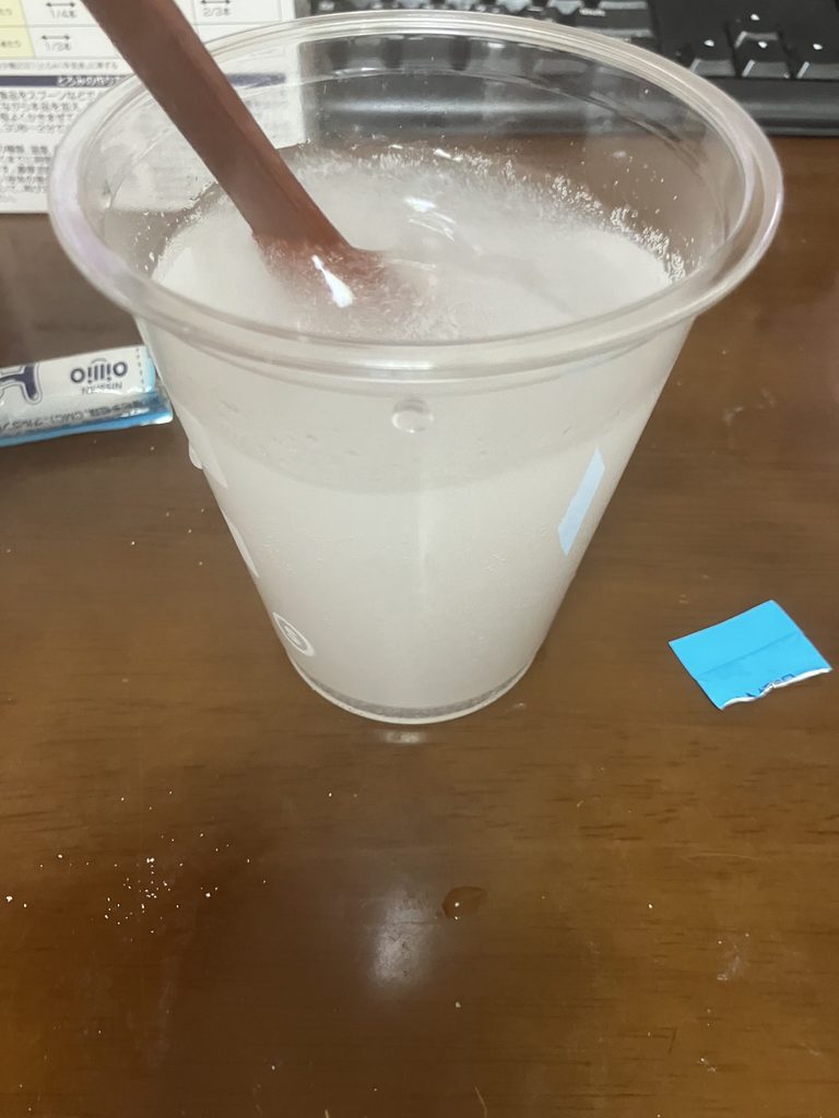 トロミアップパーフェクトを飲みものに入れて混ぜる様子